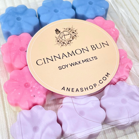 Flower-shaped cinnamon bun soy wax melts with a brand label on a white background. CINNAMON BUN MIX MINI WAX MELTS 
