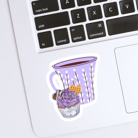 Sticker of a purple mug with a dessert on a laptop keyboard. Coffee and Blueberry Cupcake Sticker