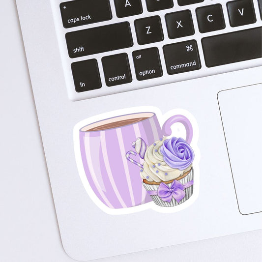 Sticker of a purple cup with a cupcake design on a laptop keyboard. Coffee with Creamy Lilac Cupcake Sticker