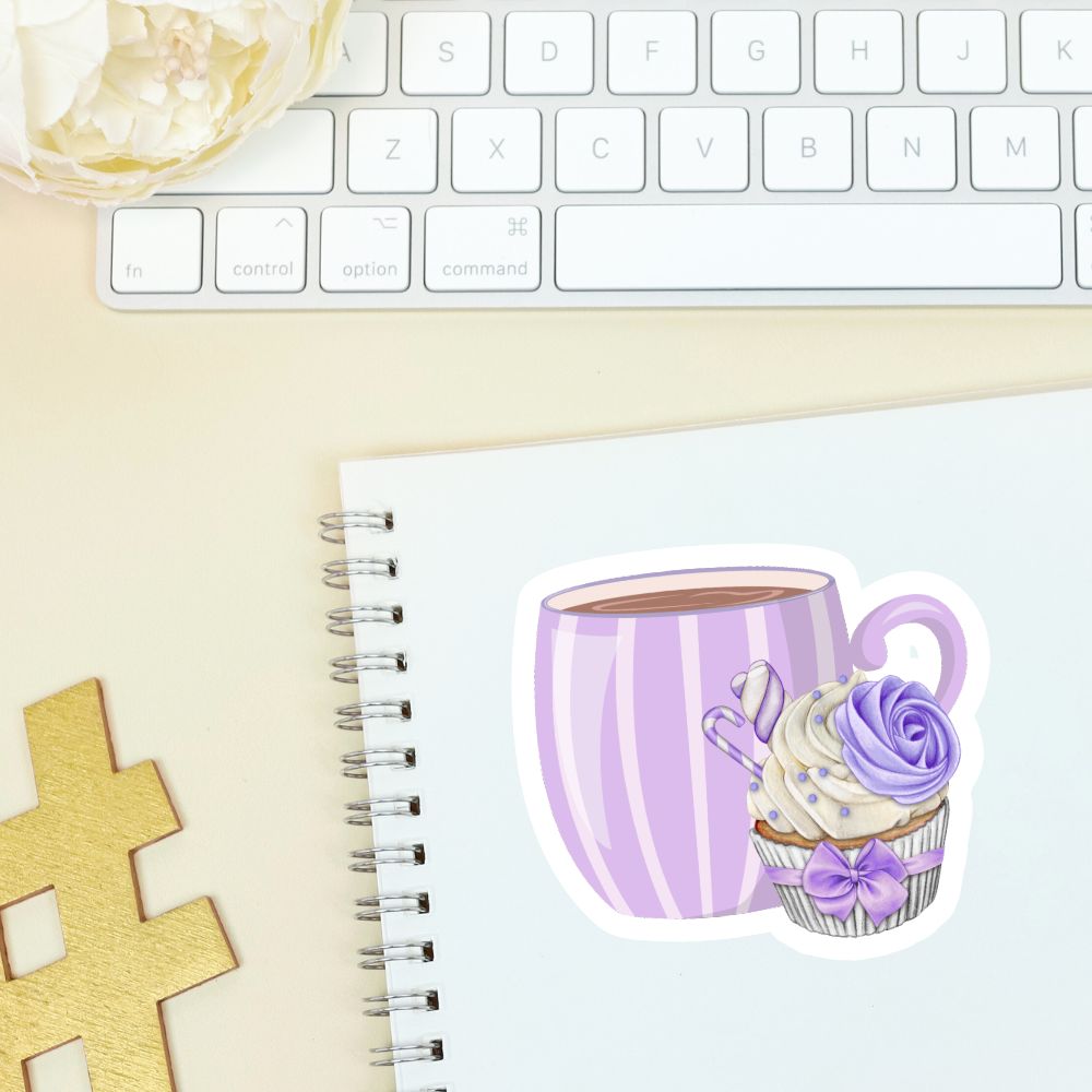 Notebook with a sticker of a purple striped mug and cupcake, next to a keyboard on a light surface.Coffee with Creamy Lilac Cupcake Sticker