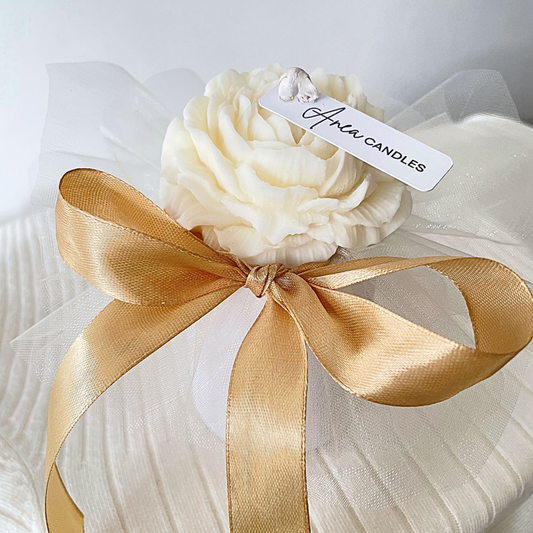 White candle shaped like a flower with a gold ribbon and 'Avery Candles' tag on a white background. SNOW PIXIE GOLD FLOWERS CANDLE BOUQUET