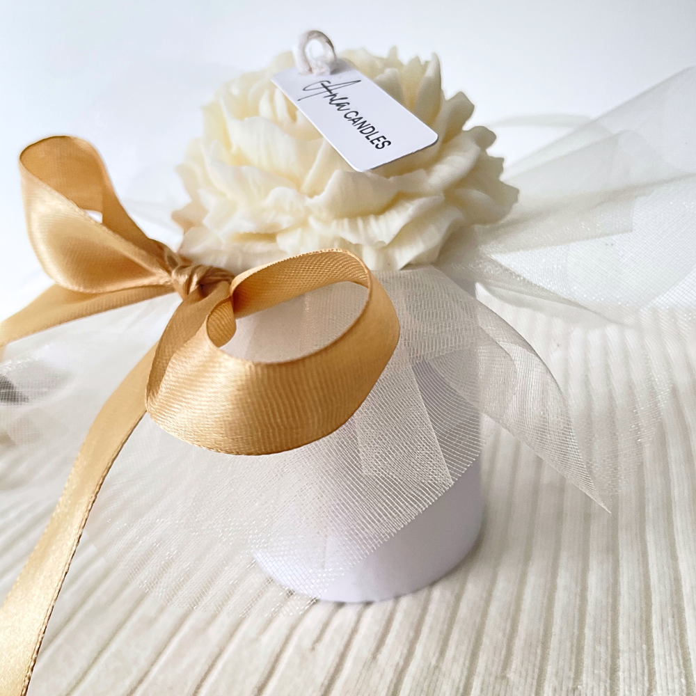 White candle in a decorative box with a gold ribbon on a white background. SNOW PIXIE GOLD FLOWERS CANDLE BOUQUET