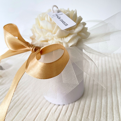 White candle in a decorative box with a gold ribbon on a white background. SNOW PIXIE GOLD FLOWERS CANDLE BOUQUET