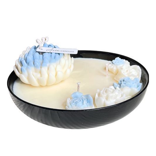 Decorative candle with blue and white floral designs in a black bowl on a white background. FLOWER NATURAL SOY CANDLE