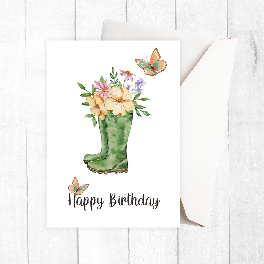 Happy Birthday card with green wellington boot holding flowers and butterflies on a white background