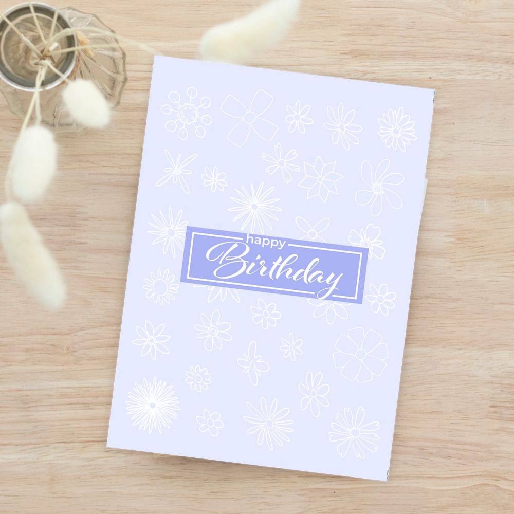 White birthday card with snowflake pattern and 'Happy Birthday' text on a wooden surface. Gentle Pastels Birthday Card