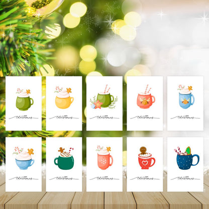 Set of Christmas cards with colorful mugs on a wooden surface with blurred greenery in the background.HOT COCOA CHRISTMAS CARDS