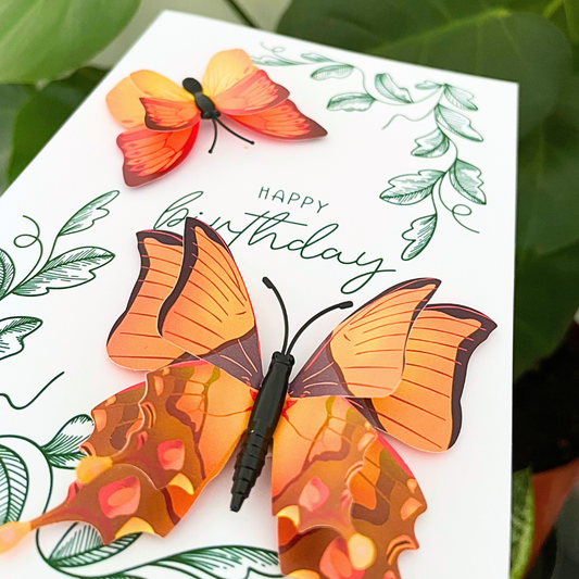 Birthday card with butterfly design and pen on a white background