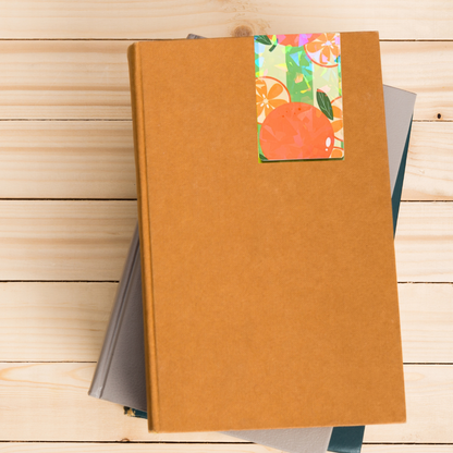 Brown notebook with a colorful fruit-themed label on a wooden surface. Juicy Fruit Bookmark Set