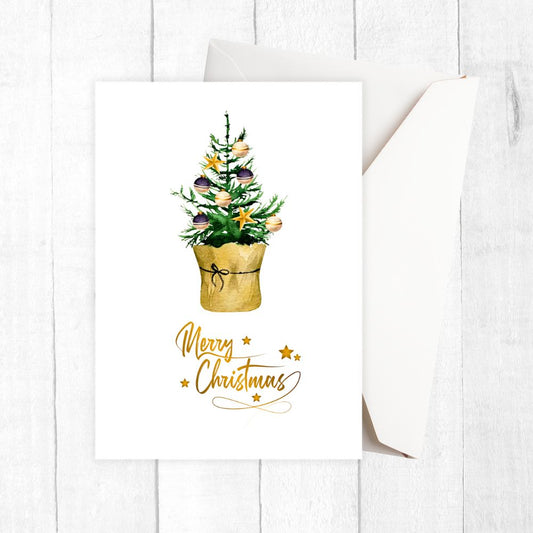 Christmas card with a small Christmas tree in a gold pot and 'Merry Christmas' text on a white background.LITTLE TREE CHRISTMAS CARD