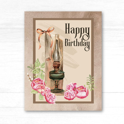 Vintage-style birthday card with oil lamp, flowers, and 'Happy Birthday' text on a textured background.