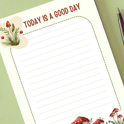 Notebook page with 'Today is a good day' text and decorative elements on a green background.MUSHROOM PERSONALISED A6 NOTEPAD