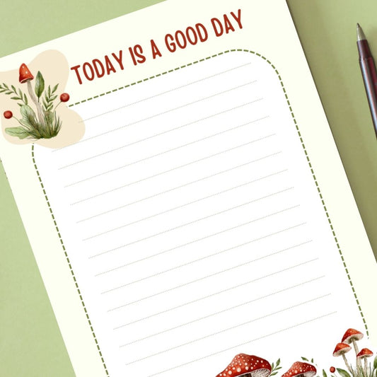 Notebook page with 'Today is a good day' text and decorative elements on a green background.MUSHROOM PERSONALISED A6 NOTEPAD