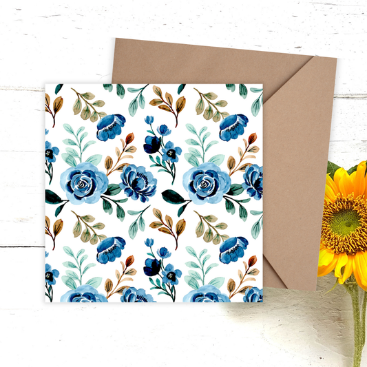 Floral card with blue flowers and green leaves, brown envelope, and sunflower on a white background. Navy Flowers Happy Birthday Card