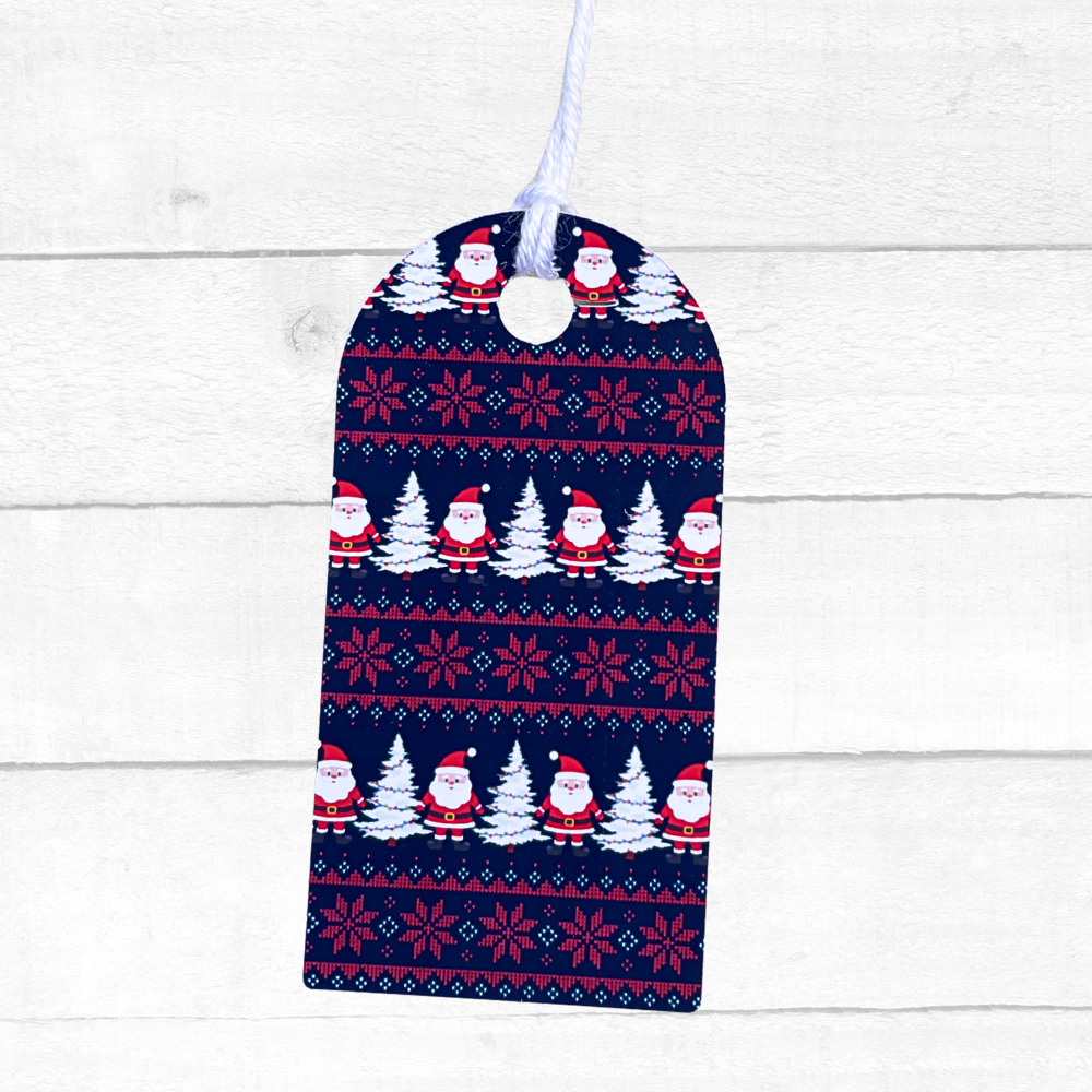 Christmas-themed bag with Santa Claus and snowflake pattern on a white wooden background. Navy Sweater Christmas Gift Tag Set