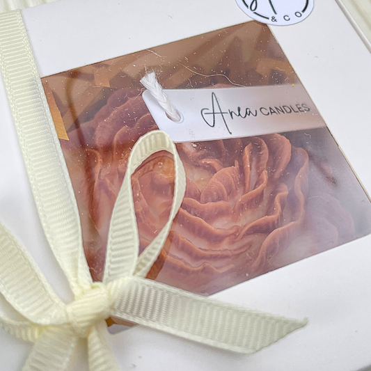 Candle in a decorative box with a bow and 'Aria Candles' label. PEONY CINNAMON BUN CANDLE GIFT BOX