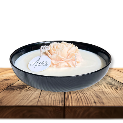 Decorative candle in a black bowl with a floral design on a wooden surface. PEONY FLOWER SOY NTURAL CANDLE