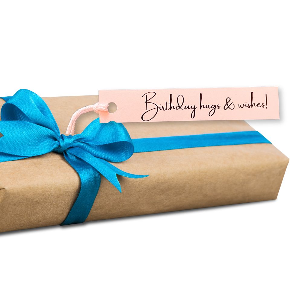 Gift wrapped in brown paper with a blue ribbon and a pink tag reading 'Birthday hugs & wishes!' on a white background.PERSONALISED PASTEL SLIM GIFT TAG SET