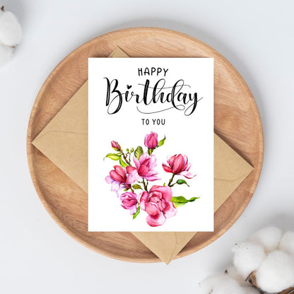Birthday card with floral design and 'Happy Birthday to You' text on a wooden plate. Pink Magnolia Happy Birthday Card