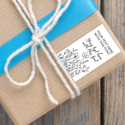 Gift wrapped in brown paper with a blue ribbon and white string, featuring a customizable label.SIMPLE PERSONALISED GIFT TAG