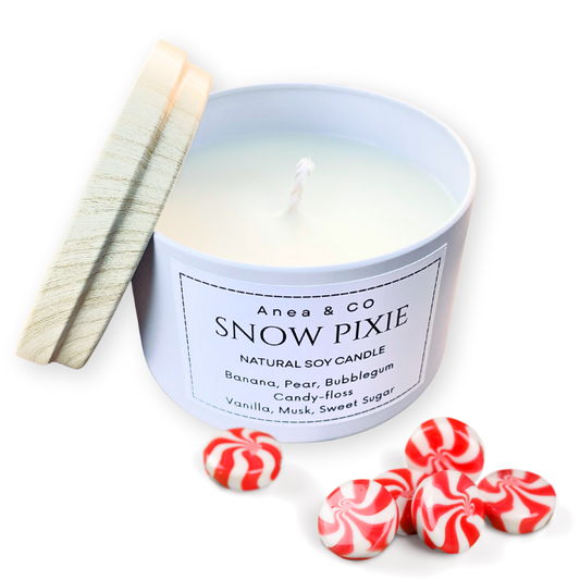Candle labeled 'Snow Pixie' by Anea & Co with peppermint candies on a white background. SNOW PIXIE SOY CANDLE