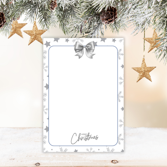 Decorative Christmas card with stars, pine cones, and a candle on a wooden surface.Silver Christmas Notepad A6 stationery