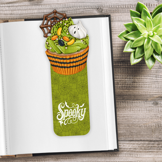 Halloween-themed bookmark with ghost and candy corn design on an open book.Spooky Halloween Green Cupcake Bookmark