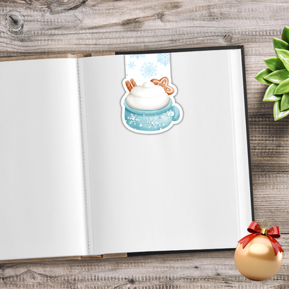 Open notebook with a sticker of a cartoon character in a snowy scene on a wooden surface. Sweet Christmas Magnetic Bookmark
