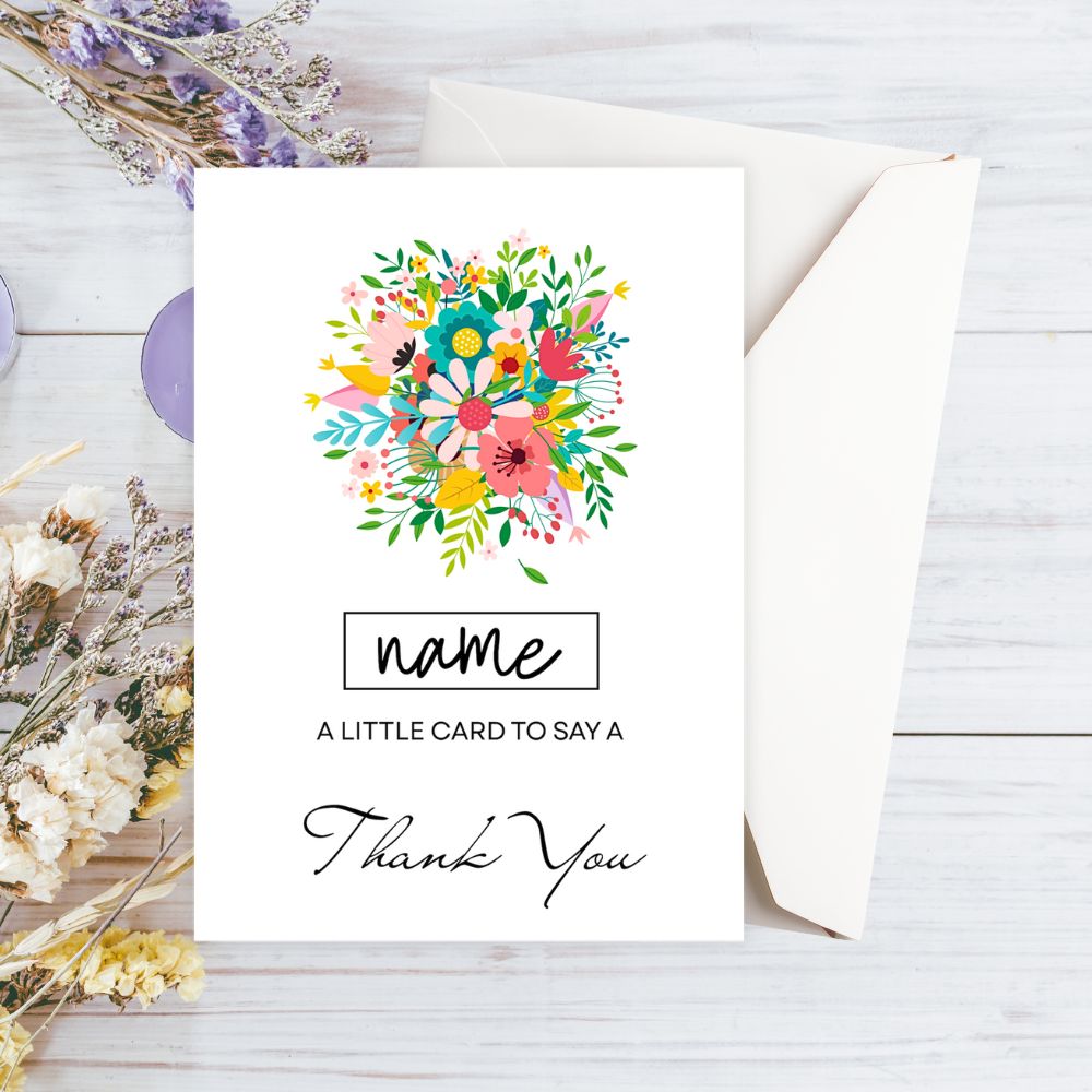 Greeting card with colorful floral design and 'name' placeholder on a wooden surface. Wild Flower Bouquet Thank You Personalised Card