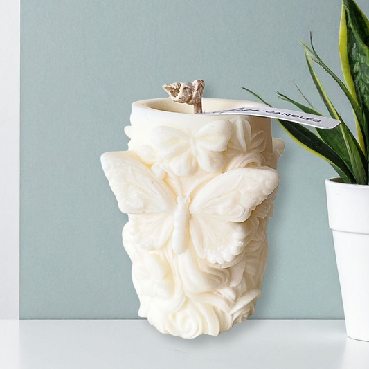 Decorative wall-mounted candle holder with butterfly design on a light blue wall.Butterfly coconut pillar candle