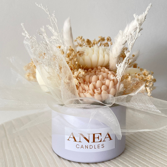 Decorative candle arrangement with dried flowers in a container labeled 'ANEA CANDLES' on a neutral background.BROWN WAX MELT FLOWER MINI BOUQUET