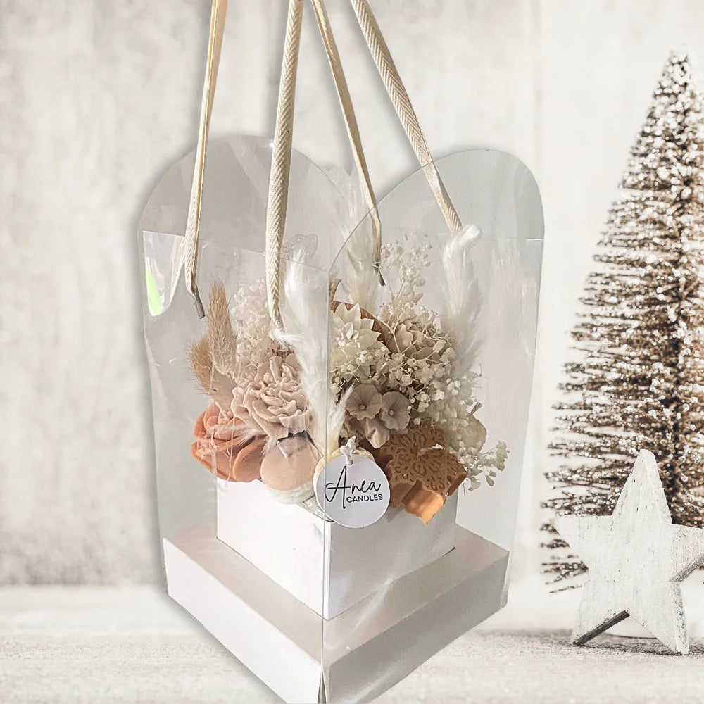 Decorative hanging bag with flowers and a visible brand label against a blurred Christmas tree background. chocolatecreamchristmascandlesbouquet2