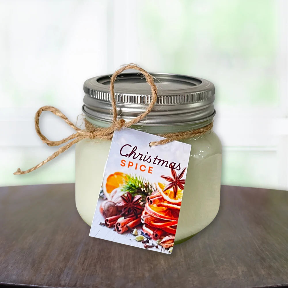 Jar of candle labeled 'Christmas Spice candle ' with a decorative tag on a wooden surface.