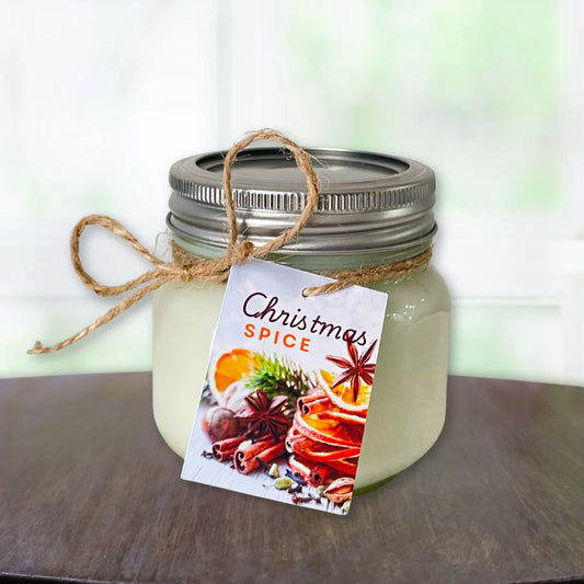Jar of candle labeled 'Christmas Spice candle ' with a decorative tag on a wooden surface.