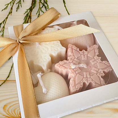 Decorative candles in a box with a gold ribbon on a wooden surface. CHRISTMAS ORNAMENTS CANDLE GIFT BOX