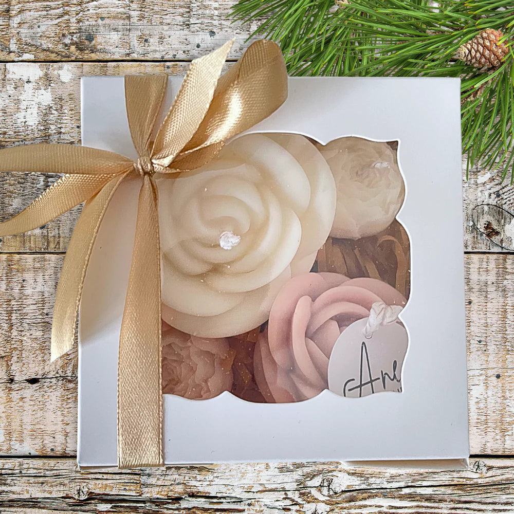 Set of soaps in a decorative box with a gold ribbon on a wooden surface. Christmas Candles