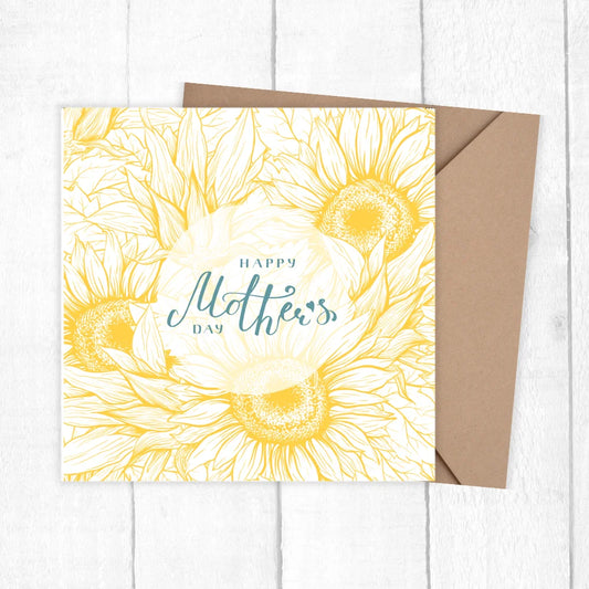 Greeting card with sunflower design and 'Happy Mother's Day' text on a white wooden surface. SUNFLOWER MOTHER'S DAY CARD