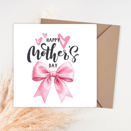 Mother's Day card with pink bow and envelope on a textured surface. MOTHERS DAY CARD