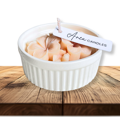 White bowl with pink candles on a wooden surface, featuring 'Anew Candles' tag. natural flower SOY CANDLE