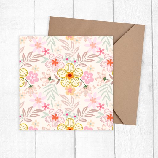 Floral card with a brown envelope on a white wooden surface. pastel Flowers Birthday Card