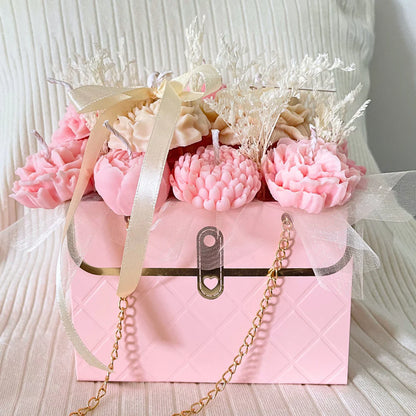 Pink gift box with decorative candles shaped like flowers on a white surface. PINK & CREAM CANDLE FLOWER BOUQUET BAG