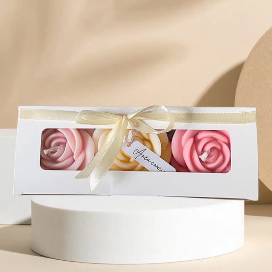 Set of three pink and white spiral candles in a box with a bow on a beige background. LARGE ROSES CANDLE GIFT BOX