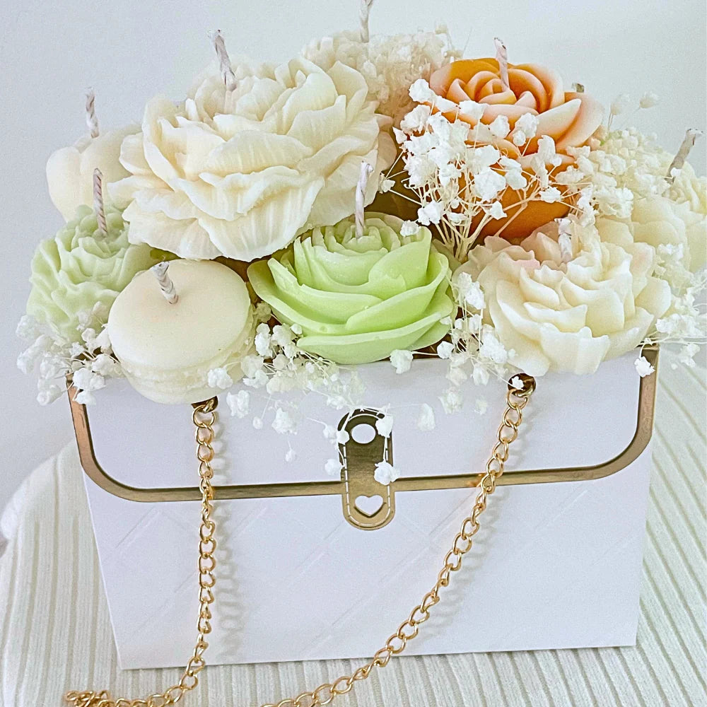Decorative arrangement of candles shaped like flowers in a white box with a gold chain.SUMMER CANDLE FLOWER BOUQUET BAG